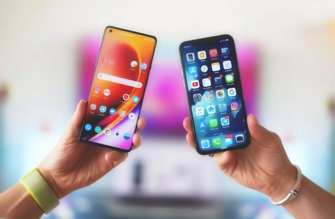 Android and iOS smartphones in two hands